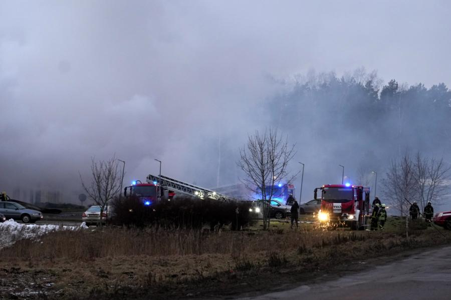 Valmieras pusē deg divstāvu māja, piekabe, malkas grēda un koki; cietis glābējs