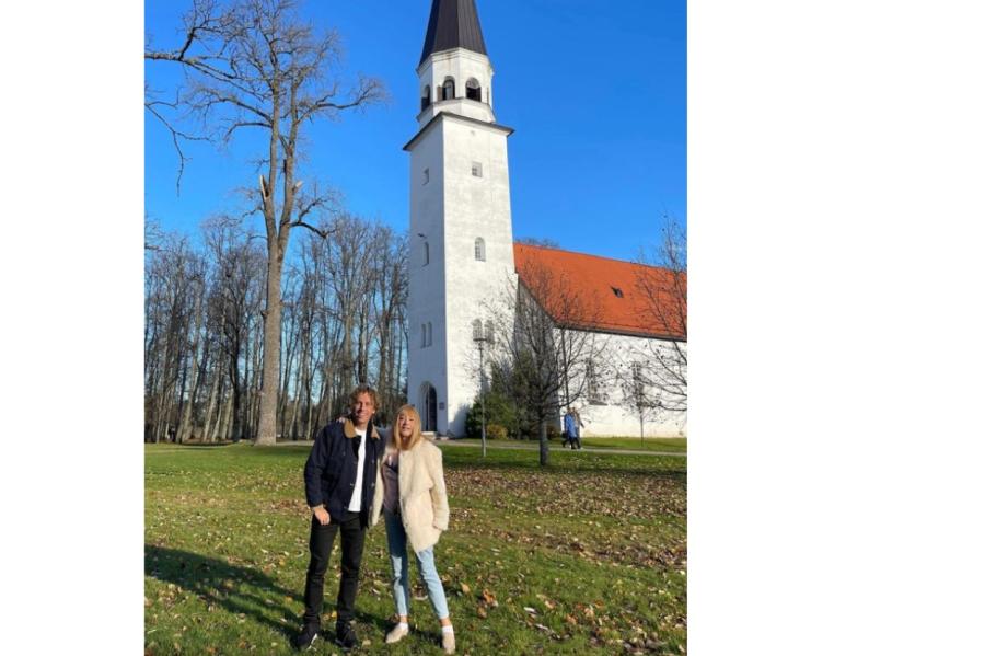  Alla un Maksims fotografēti uz senas baznīcas fona Latvijas pilsētā.