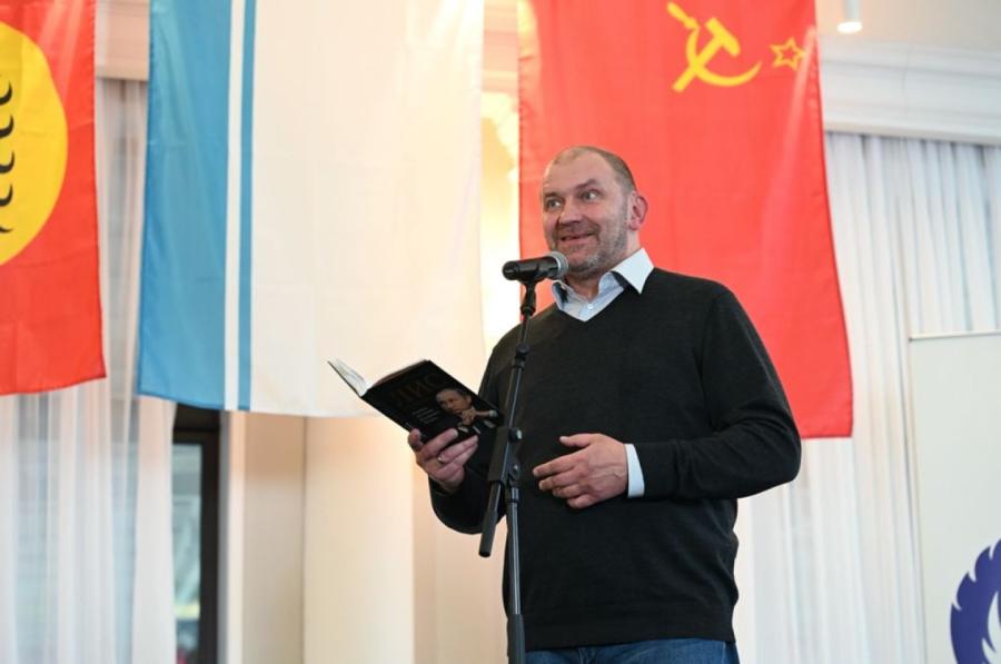 Saukdams sevi par pareizticīgo, Kazakovs pozē uz boševiku simbolu fona. 